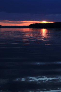 Nehrin üzerinde renkli dramatik günbatımı. Ormanın üzerinde gün batımı ufku, doğal manzara. Yaz tatili kavramı. Güzel doğal arkaplan