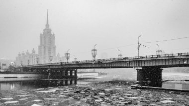View of the Hotel Ukraine and the Moscow river in winter. Snowfall in the city. clipart