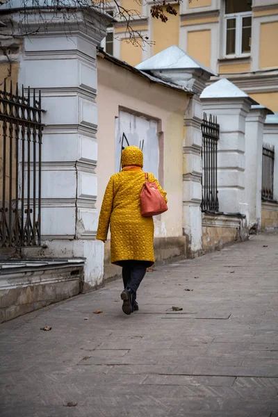 Una Mujer Con Una Chaqueta Amarilla Camina Largo Una Vieja —  Fotos de Stock