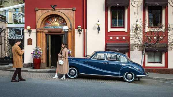 Moskova 'nın göbeğinde bir yan sokakta antika bir araba ve palto giymiş bir kız..