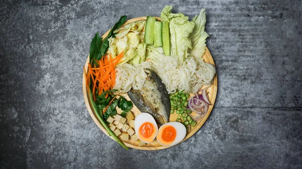 Baharatlı pirinç erişteli salata çimento masasında otla birlikte..