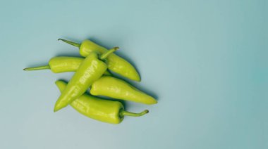 Açık mavi arkaplanda yeşil tatlı biberler