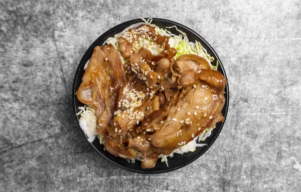 Soya soslu ızgara domuz eti ve beton masada susam tohumu...