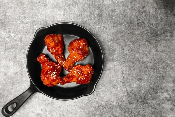 Gri beton masada Kore soslu kızarmış tavuk kanadı..