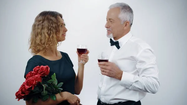 An elderly couple raises their glasses of wine at a celebration. Happy elderly