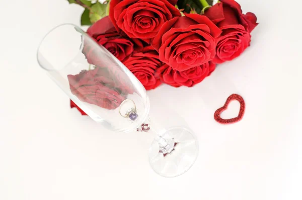 Kırmızı gül ve yüzük bir cam