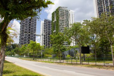 Singapur caddesinde yeşil çimenli ve yapraklı yüksek binalar