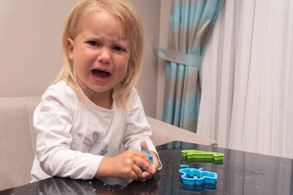 Плаче кавказька дитина грає з барвистим ігровим тістом — стокове фото