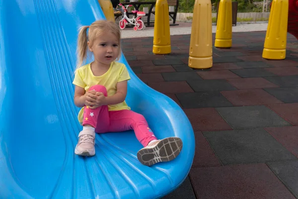 Cute little caucasian child sits on a slide after riding — Φωτογραφία Αρχείου