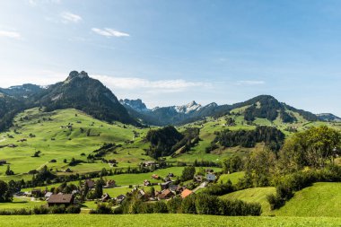 Toggenburg 'da yeşil çayır ve otlaklar, arkada Speer (sağda) ve Mattstock (solda) dağları, İsviçre' de Canton St. Gallen, Canton