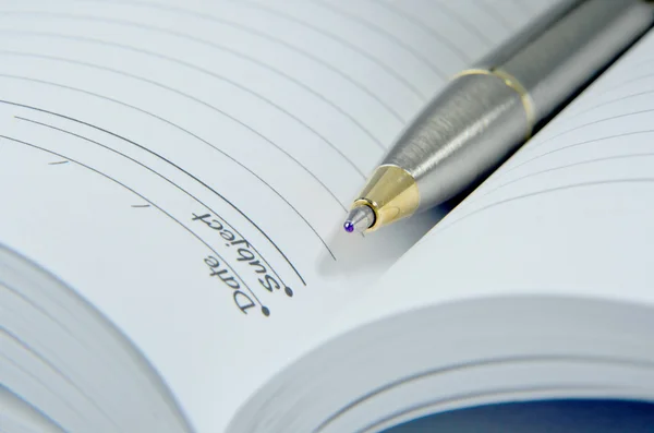 Cuaderno abierto con pluma, aislado en blanco — Foto de Stock