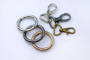 Sırt çantası kayışı için krom metal karabinalar. Bir kadın çantası için yuvarlak karabina. Şık krom döşemeler. Çantalar, aksesuarlar, metal tokalar. Kırpma yolu ile anahtar halkası. 