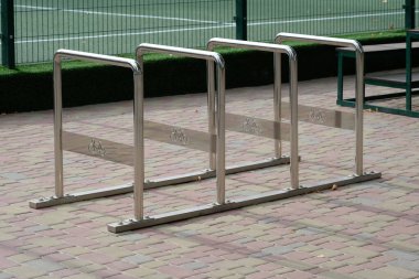 Dükkanın yakınına boş bisiklet parkı. Şehrin kaldırımında dikey bisiklet parkı. Bisiklet parkın yanında duruyor..