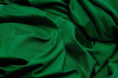 Yeşil kumaş üst görünümü katlar. Polyester kumaş yakın plan. Tekstil, doğal desen, kumaşın parlak dokusu..