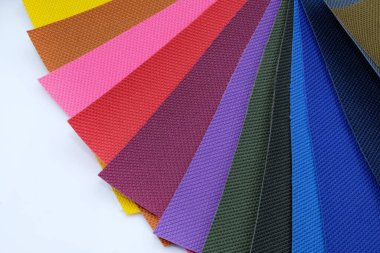 Beyaz arkaplandaki renk paleti. Farklı renklerde kumaş örnekleri. Dikiş torbaları ve sırt çantaları için kalın kumaş. 