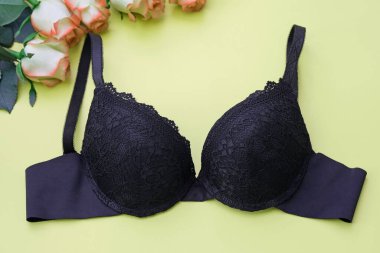 Yeşil arka plan manzaralı siyah sutyen. Kadınların dantel iç çamaşırları. Siyah sütyen, destekli bardaklar ve yeşil arka planda pürüzsüz omuz askıları.. 