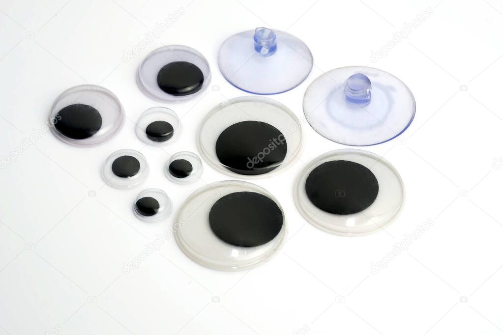 Plastic eyes for toys on a white background. Elements from plastic for sewing toys. And two suction cups.