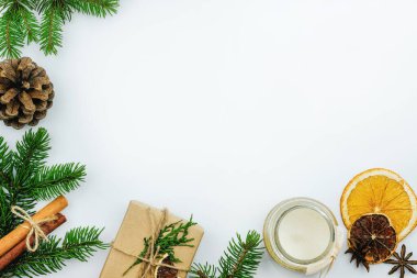 Noel ağacı filizleri, tarçın çubukları ve kuru portakallar. Mum, portakal, yıldız anason ve Noel hediyeli yeni yıl kompozisyonu