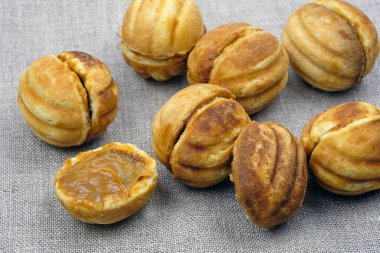 Yoğunlaştırılmış sütle ev yapımı çerezler. Ev yapımı kurabiye. Lezzetli kurabiyeler. Gri masa örtüsüne kaynamış konsantre sütle doldurulmuş ev yapımı kurabiyeler..