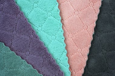 Renkli mikrofiber kumaş. Renkli mikrofiber temizleme bezleri arka planda. Silme işlemi üst görünümü kapatır.
