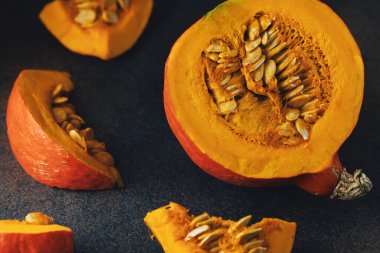 Darl arka planda tohumlu balkabağı dilimleri. Üst görünüm