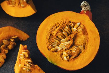 Darl arka planda tohumlu balkabağı dilimleri. Üst görünüm