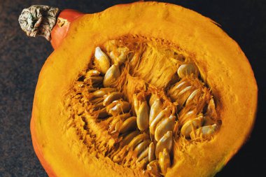 Darl arka planda tohumlu balkabağı dilimleri. Üst görünüm