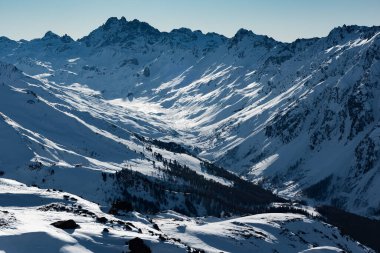 Mavi gökyüzü ve parlak beyaz karlı Alp kayak merkezinde güneşli bir kış günü Ischgl ve Samnaun, Silvretta Arena, Avusturya - İsviçre