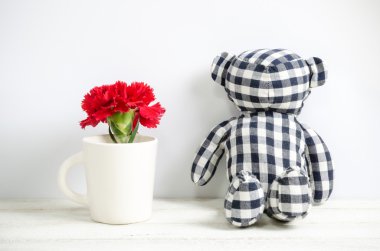 Oyuncak ayı ve kırmızı karanfil çiçek 