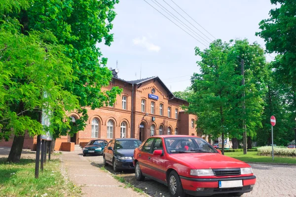 Wielkopolska Pobiedziska 火车站大楼 夏季照明 前景中的汽车 — 图库照片