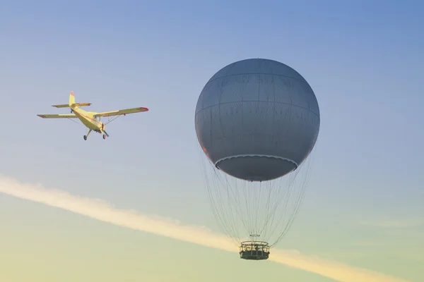 Balon gazowy i żółty samolotów przed niebo — Zdjęcie stockowe