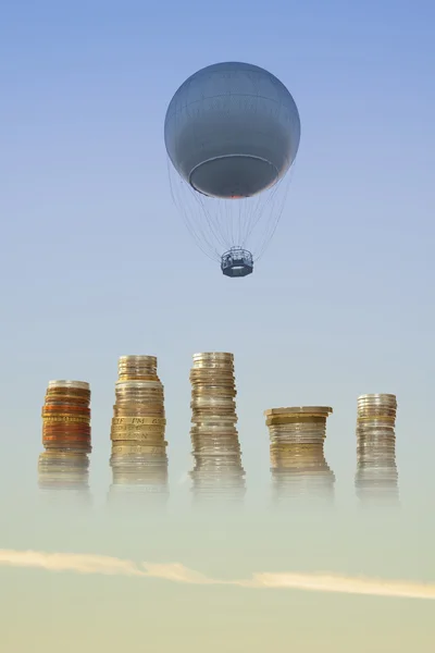 Gasballon und Münzen gegen den Himmel — Stockfoto