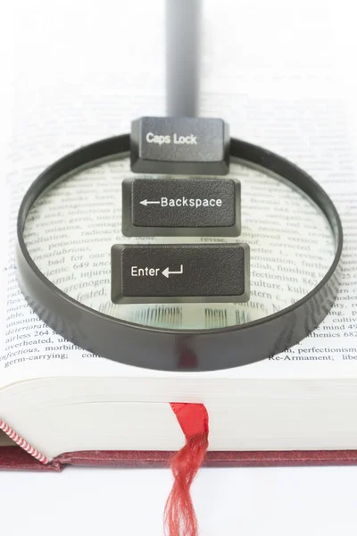 Enter, Backspace, CapsLock Computer Keys on a magnifying glass — Stockfoto