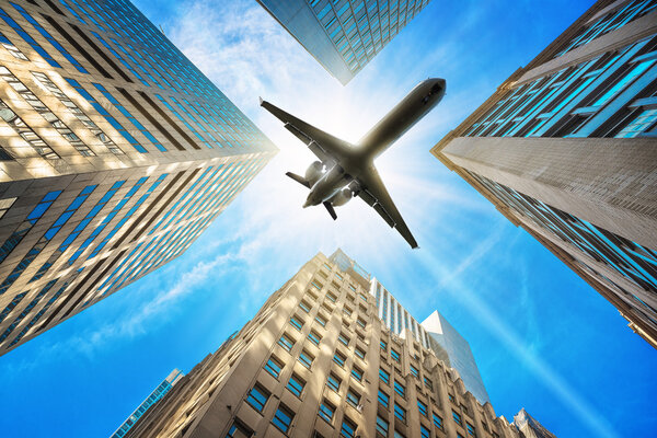 airplane over skyscrapers