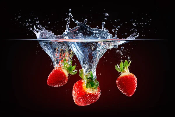新鲜草莓掉进泼洒的水中 — 图库照片