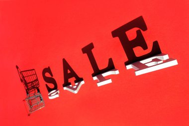 Kelime satışı, boş alışveriş arabası ve kırmızı arka planda gölge. Kara Cuma 'yı ve satışı hesaba kat. Tasarım, reklam veya reklam için yaratıcı şablon.