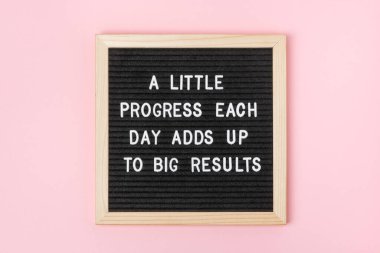 Her gün biraz ilerleme büyük sonuçlar doğurur. Pembe arka planda siyah harf tahtasından motivasyon alıntısı. Günün ilham verici alıntısını kabul et. Tebrik kartı, kartpostal.