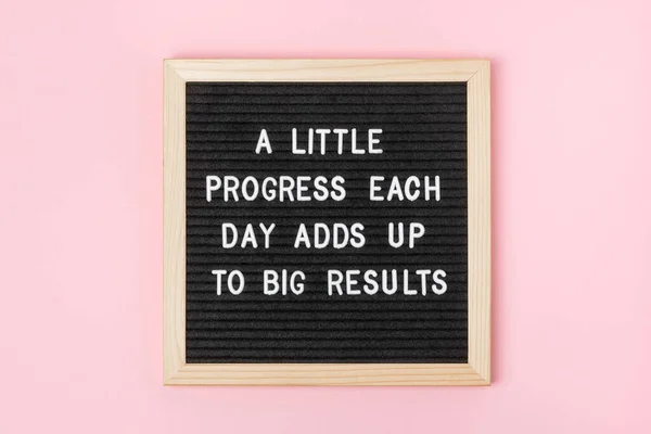 A little progress each day adds up to big results. Motivational quote on black letter board on pink background. Concept inspirational quote of the day. Greeting card, postcard