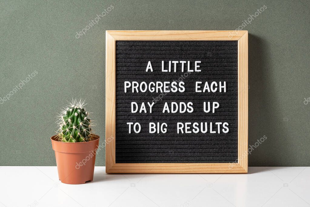 A little progress each day adds up to big results. Motivational quote on letter board, cactus, succulent flower on white table. Concept inspirational quote of the day. Front view.