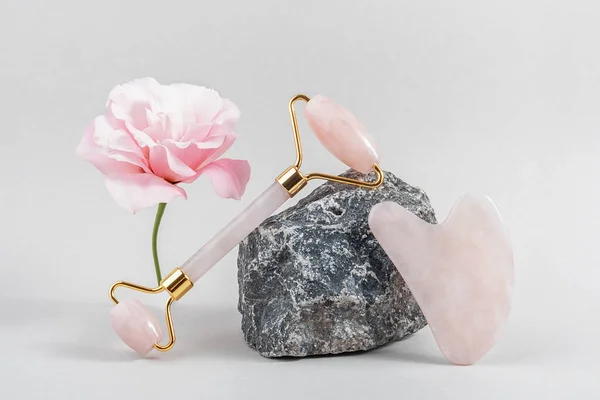 Kristall Rosenquarz Gesichtsroller Und Massagegerät Jade Gua Sha Auf Steinen — Stockfoto