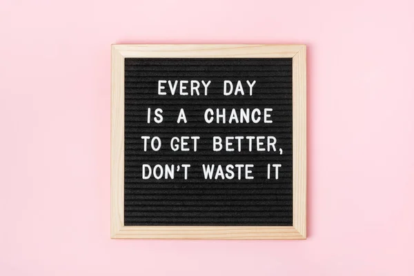 Every day is a chance to get better, don\'t waste it. Motivational quote on black letter board on pink background. Concept inspirational quote of the day. Greeting card, postcard.