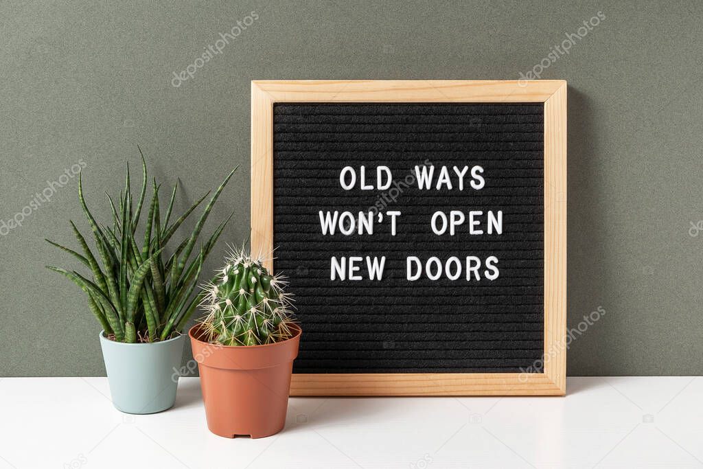 Old Ways Won't Open New Doors. Motivational quote on letter board, cactus, succulent flower on white table. Concept inspirational quote of the day. Front view.