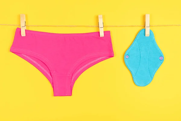 青エコ再利用可能な生理用パッドと洗浄ライン上のピンクのパンツ 黄色の背景 ヘルスケアと廃棄物ゼロ プラスチックなし 環境に優しいコンセプト — ストック写真