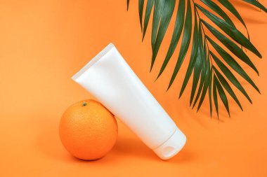 Beyaz boş kozmetik şişesi, bir tüp krem vücut, yüz ya da el losyonu, portakal suyu ve palmiye dalı. C vitamini, antioksidan ya da antiselülit içeren kozmetik ürünler. Model Ön Görünüm.