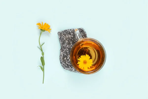 Ένα Φλιτζάνι Τσάι Βοτάνων Πέτρα Και Λουλούδι Καλέντουλας Μπλε Φόντο — Φωτογραφία Αρχείου