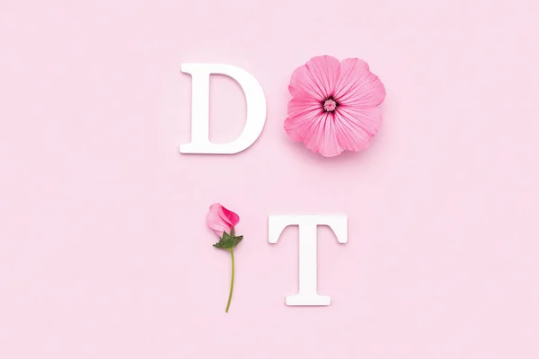 Do it. Motivational quote from white letters and beauty natural flowers on pink background. Creative concept inspirational quote of the day.