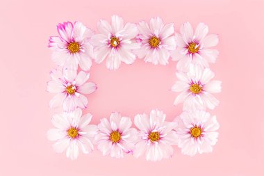 Çerçeve pembe arka planda çiçeklerle yapılmış. Üst Görünümü Düzleştir Boşluğu Kopyala.