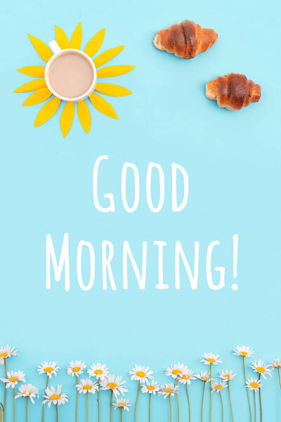 Творческая концепция "Доброе утро". Кофе, круассаны и ромашковые цветы на синем фоне. Завтрак для хорошего настроения.