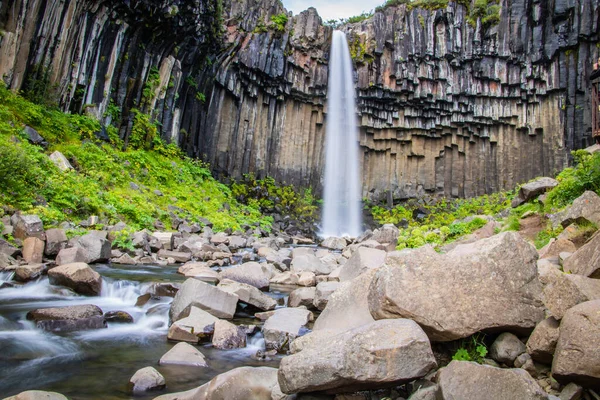 Cachoeira poderosa e magnífica com rocha vulcânica em uma paisagem islandesa — Fotografia de Stock