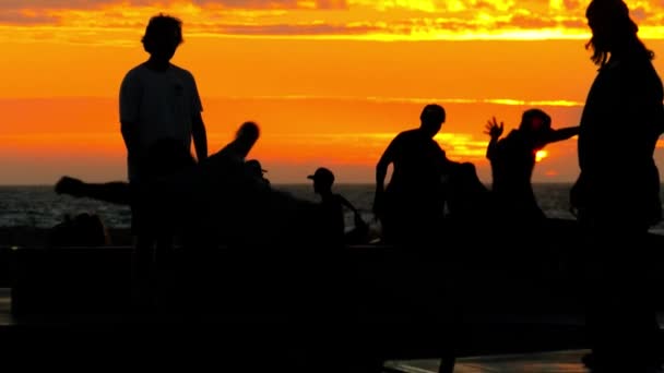Lidé skateboardingu v slavné Santa Monika skatepark při západu slunce. — Stock video